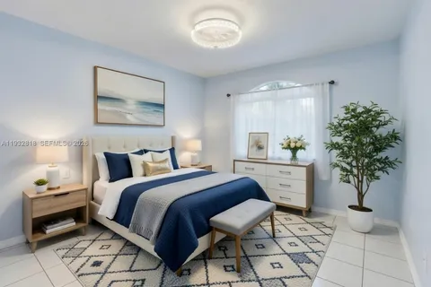 a bedroom with a bed and a potted plant