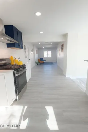 a view of a kitchen with wooden floor and a refrigerator