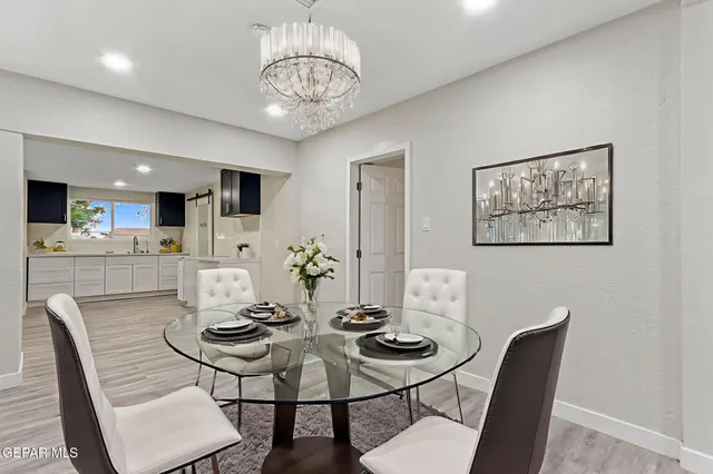 a kitchen with a refrigerator a stove and white cabinets with wooden floor