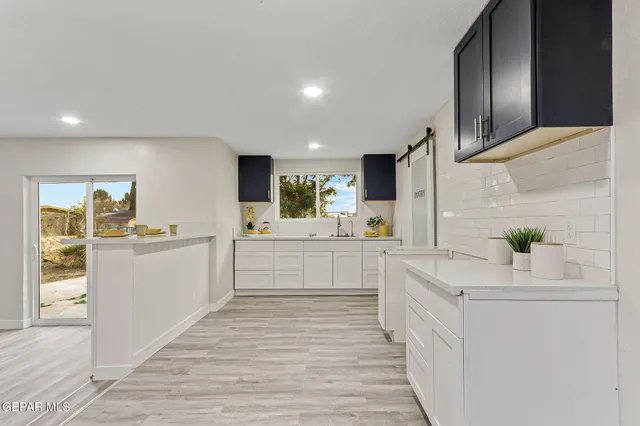 a view of a kitchen with wooden floor and windows