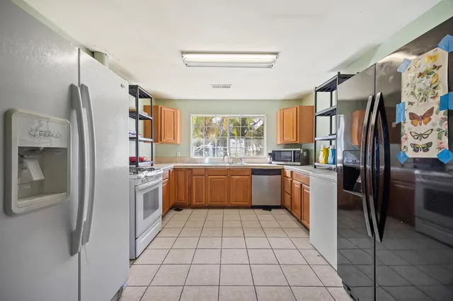a kitchen with stainless steel appliances granite countertop a refrigerator and a stove top oven