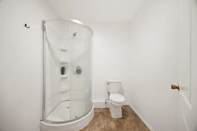 a bathroom with a toilet and a shower