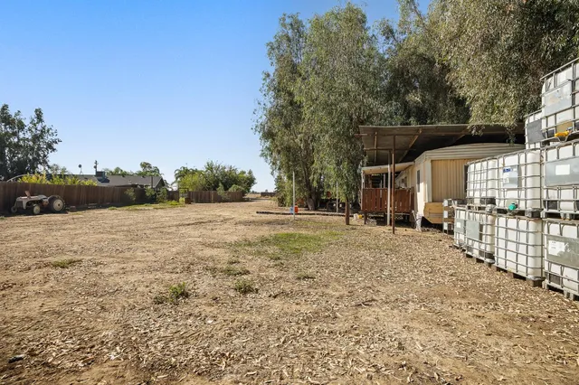 a view of a house with backyard and trees