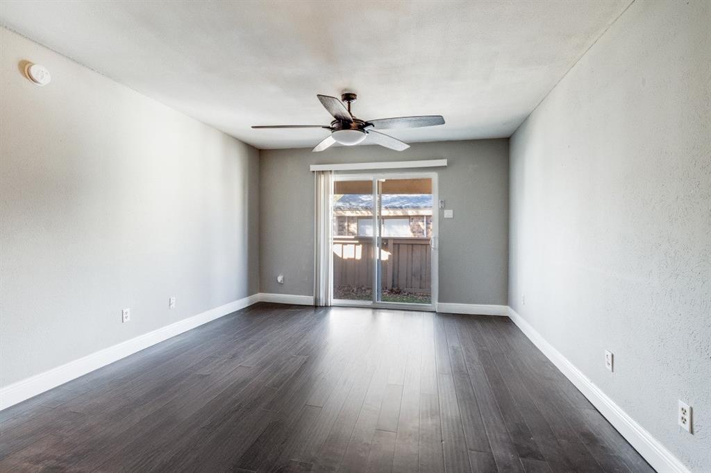 8110 Skillman Street, Unit 2019 Dallas, TX 75231 - Photo 3 of 13 an empty room with chandelier fan and windows