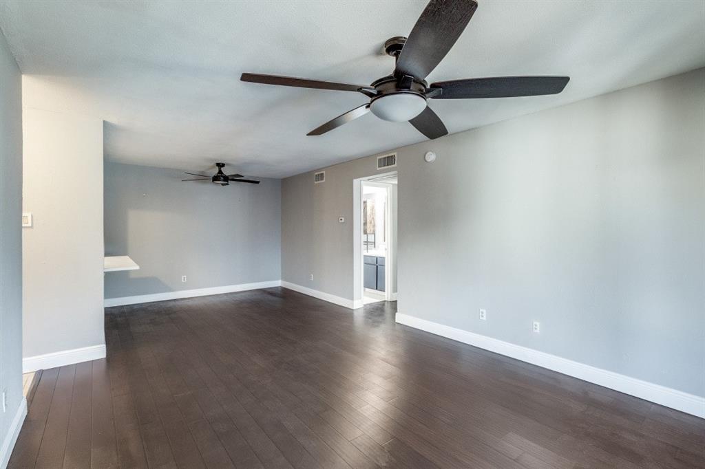 8110 Skillman Street, Unit 2019 Dallas, TX 75231 - Photo 4 of 13 an empty room with wooden floor ceiling fan and windows