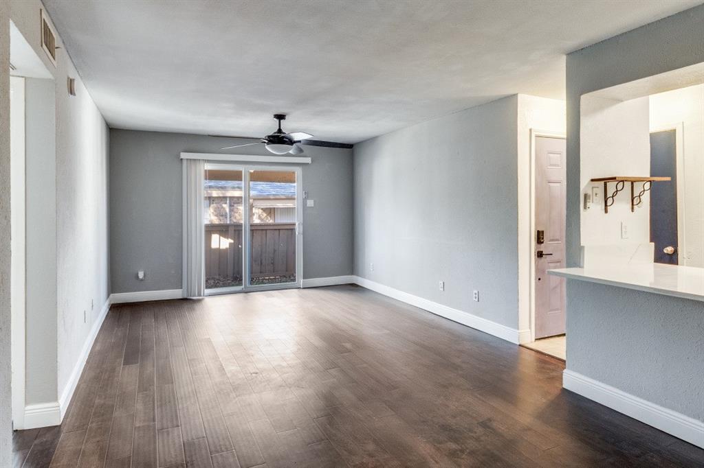 8110 Skillman Street, Unit 2019 Dallas, TX 75231 - Photo 5 of 13 an empty room with window and wooden floor