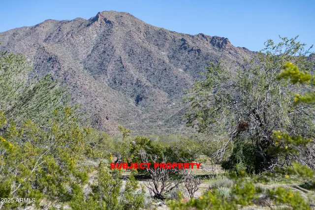 a view of a large mountain with mountains in the background
