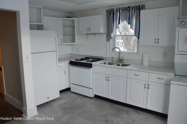 a kitchen with white cabinets and a sink