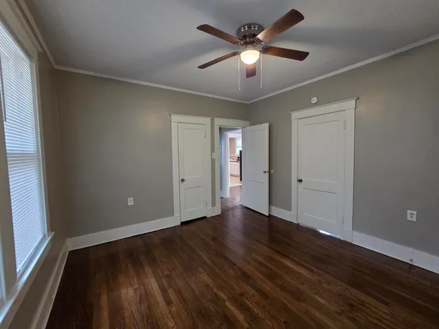 an empty room with wooden floor and windows