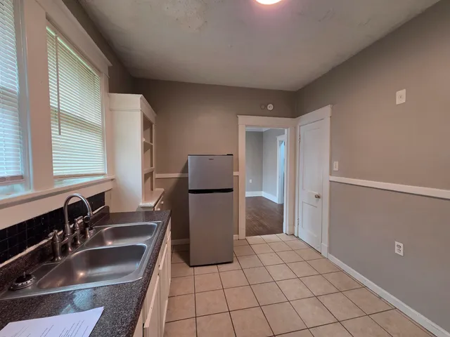 a kitchen with a sink a refrigerator and cabinets