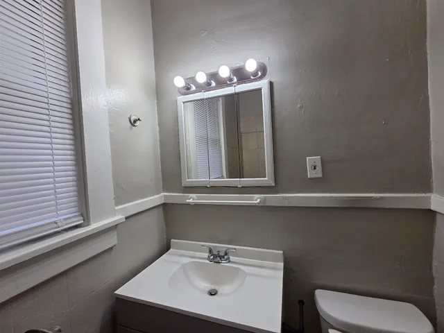 a bathroom with a toilet sink and mirror