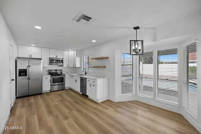 a kitchen with a refrigerator a sink and cabinets