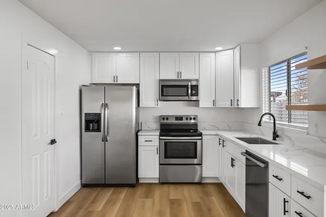 a kitchen with stainless steel appliances a refrigerator sink and microwave