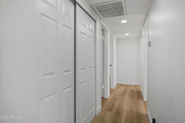 a view of a hallway with wooden floor