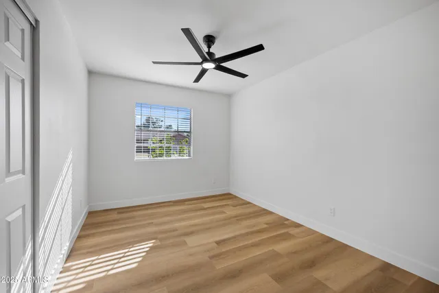 a view of a big room with wooden floor and windows