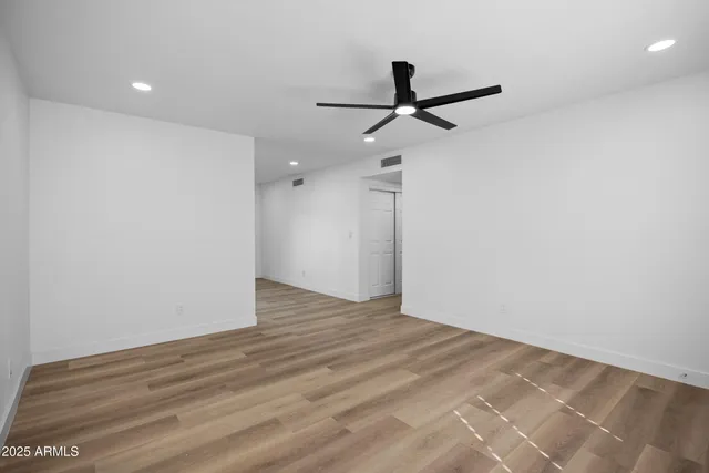 a view of empty room with wooden floor