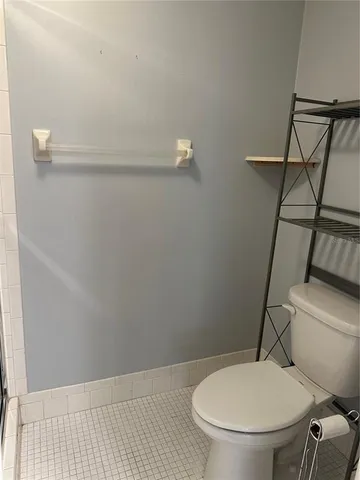 a white toilet sitting next to a shower