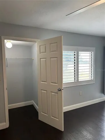 an empty room with wooden floor and window