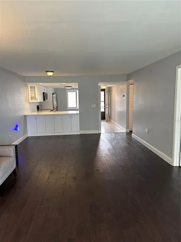 a view of a kitchen with wooden floor and a window