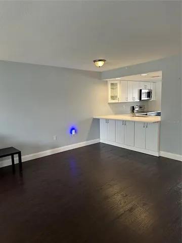 a view of kitchen with wooden floor and electronic appliances