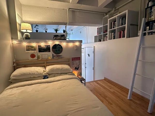 a bed sitting in a bedroom and wooden floor