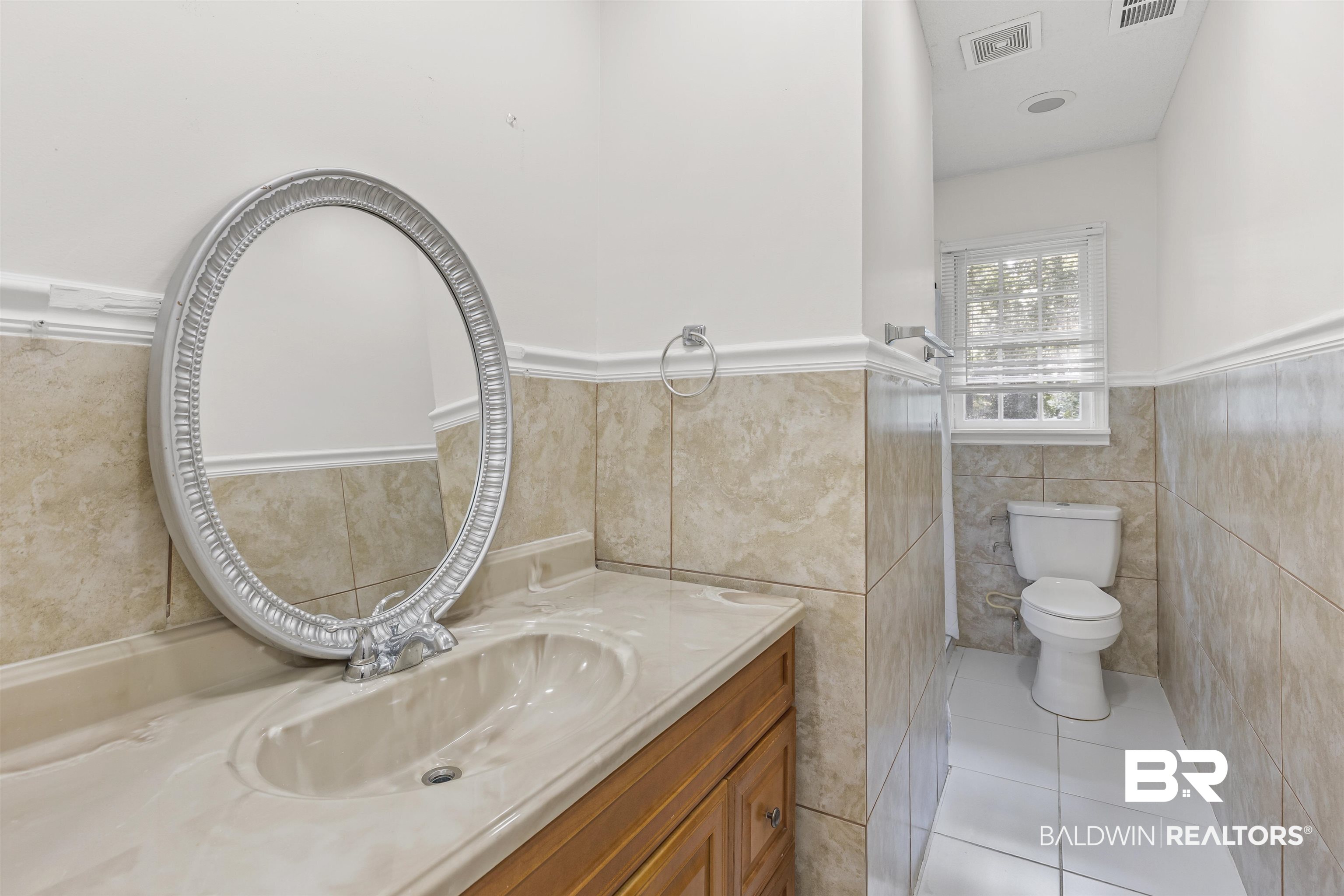 1108 Locarno Street Mobile, AL 36608 - Photo 13 of 24 Bathroom with tile walls, a wainscoted wall, tile patterned floors, and vanity