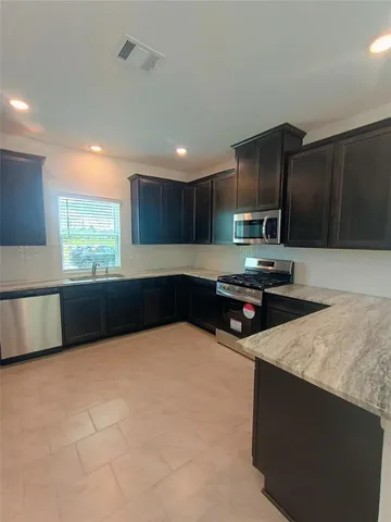 a kitchen with granite countertop a stove and a sink