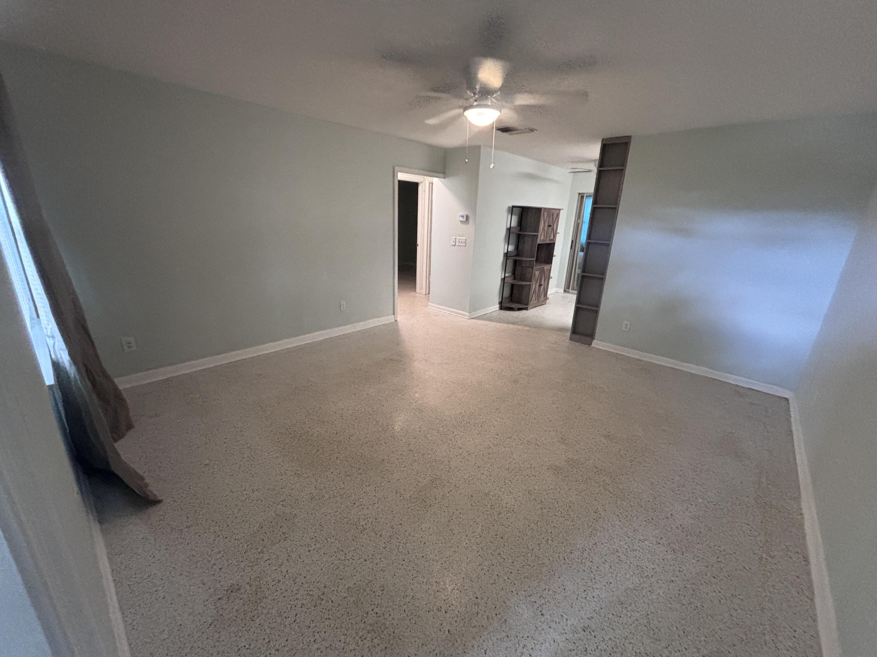 202 Balboa Street, Unit A Fort Pierce, FL 34949 - Photo 4 of 10 an empty room with chandelier fan and windows