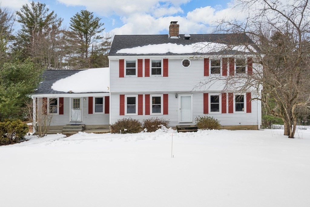 a front view of a house with a yard covered in snow