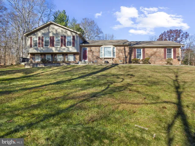 a front view of a house with a garden and lake view