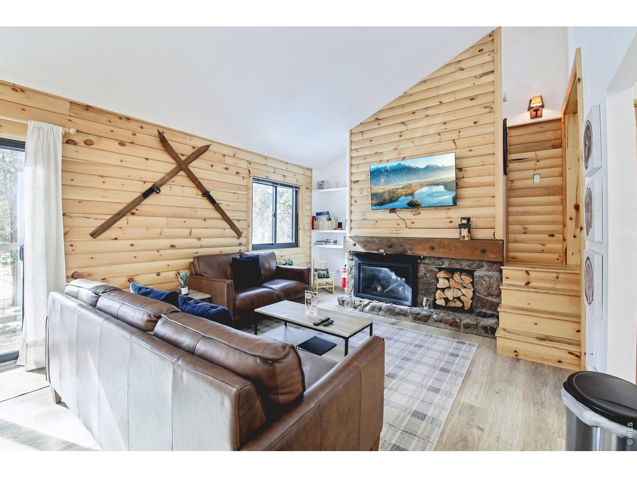 a living room with furniture a fireplace and a floor to ceiling window