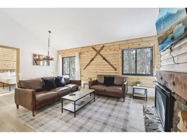 a living room with furniture a flat screen tv and a wooden floor