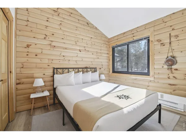 a bedroom with a bed and a lamp on dresser