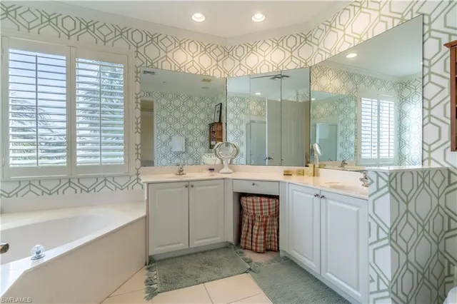 a spacious bathroom with a double vanity sink mirror and a bathtub