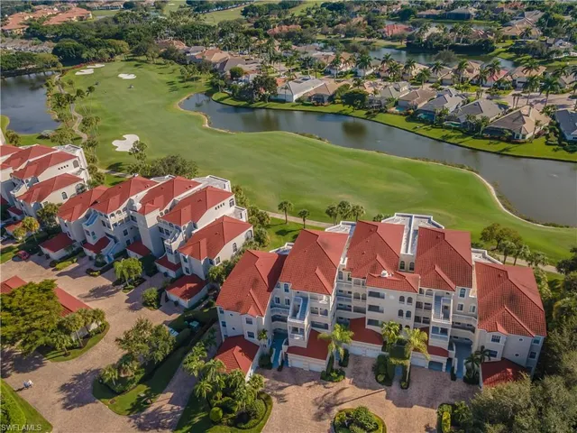 a view of a swimming pool with a lawn chairs under palm trees