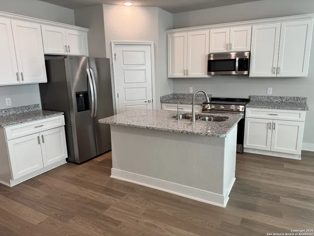 a kitchen with stainless steel appliances granite countertop a refrigerator sink and stove