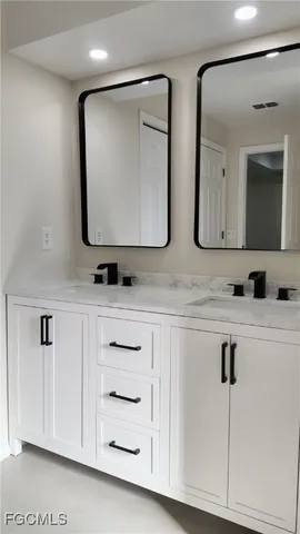 a bathroom with double vanity sink and mirror