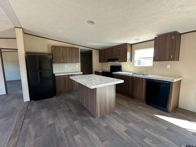 a kitchen with a sink a refrigerator and cabinets