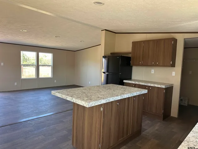 a kitchen with a wooden floor and a refrigerator