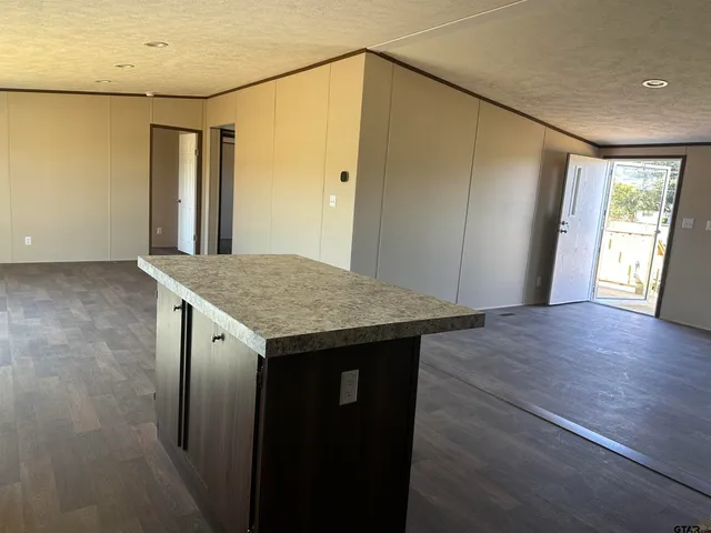 an empty room with wooden floor and entrance