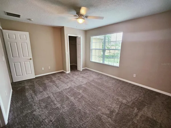 an empty room with windows and closet