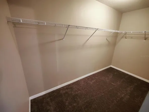 an empty room with windows and ceiling fan