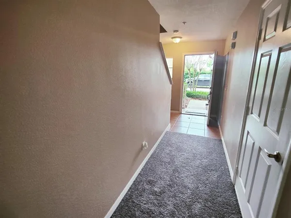 a view of a hallway with wooden floor and a livingroom