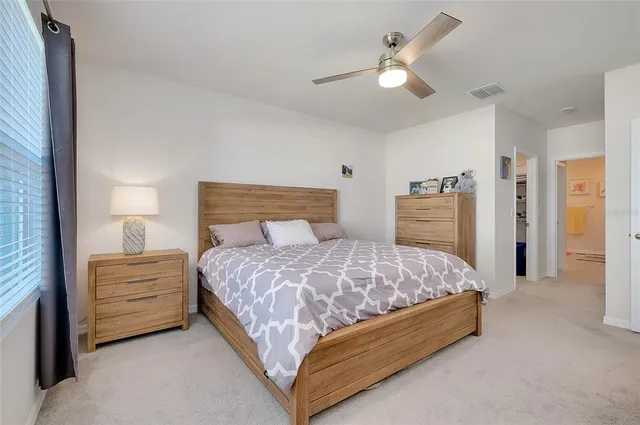 a bedroom with a bed and a lamp on dresser