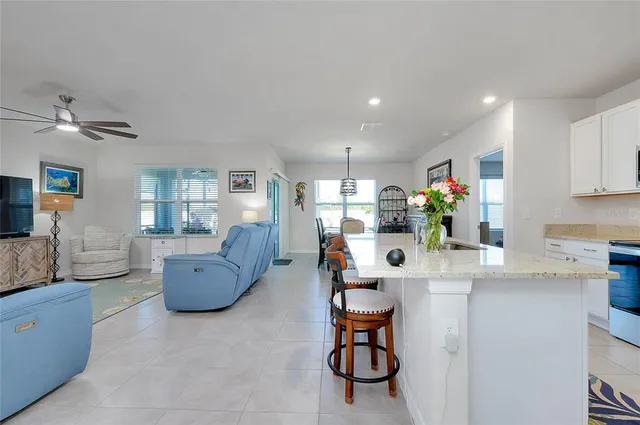 a living room with furniture kitchen view and a large window