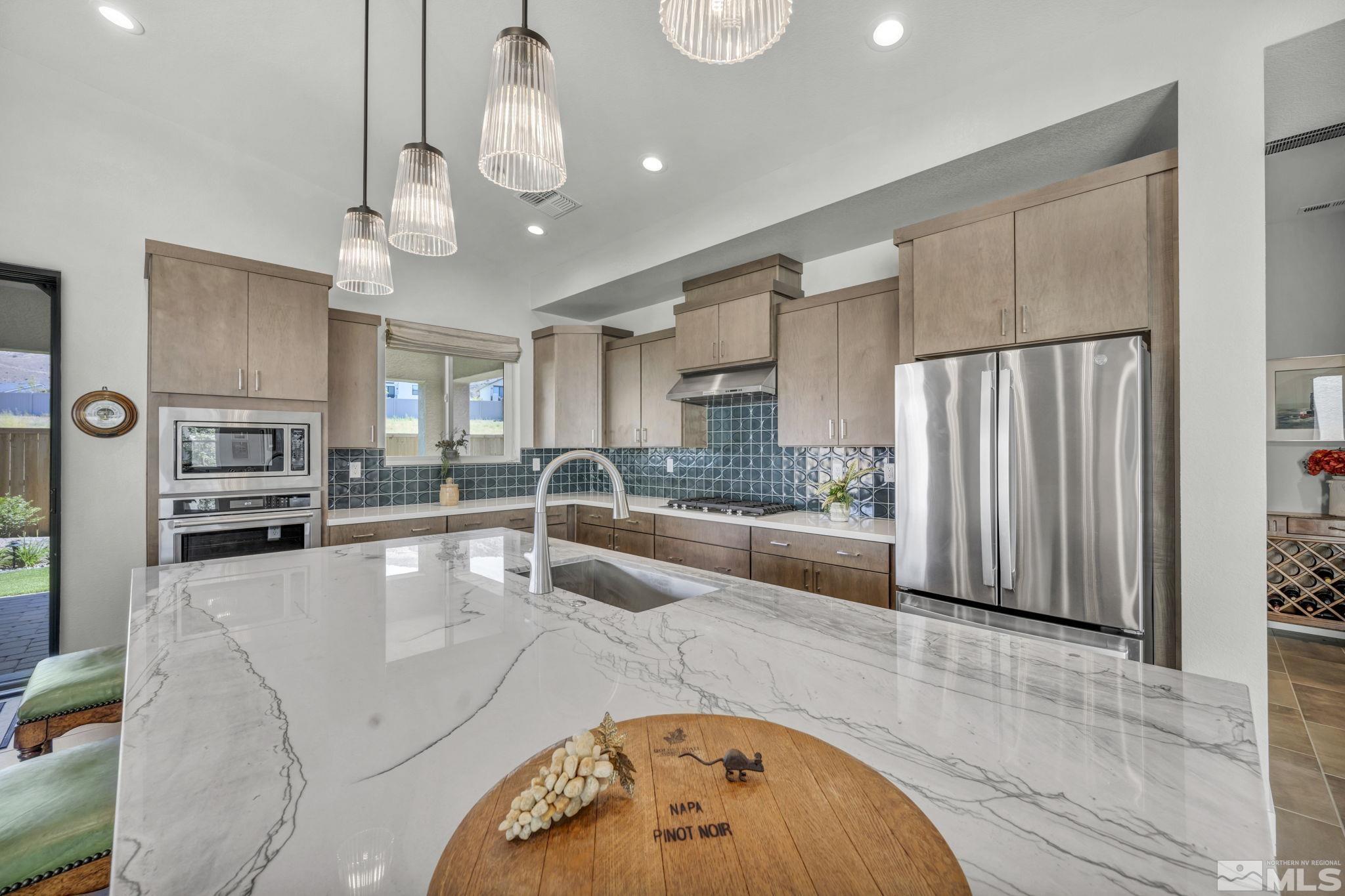 14028 Prairie Land Way Reno, NV 89521 - Photo 13 of 39 a large kitchen with stainless steel appliances granite countertop a granite counter tops and a view of living room