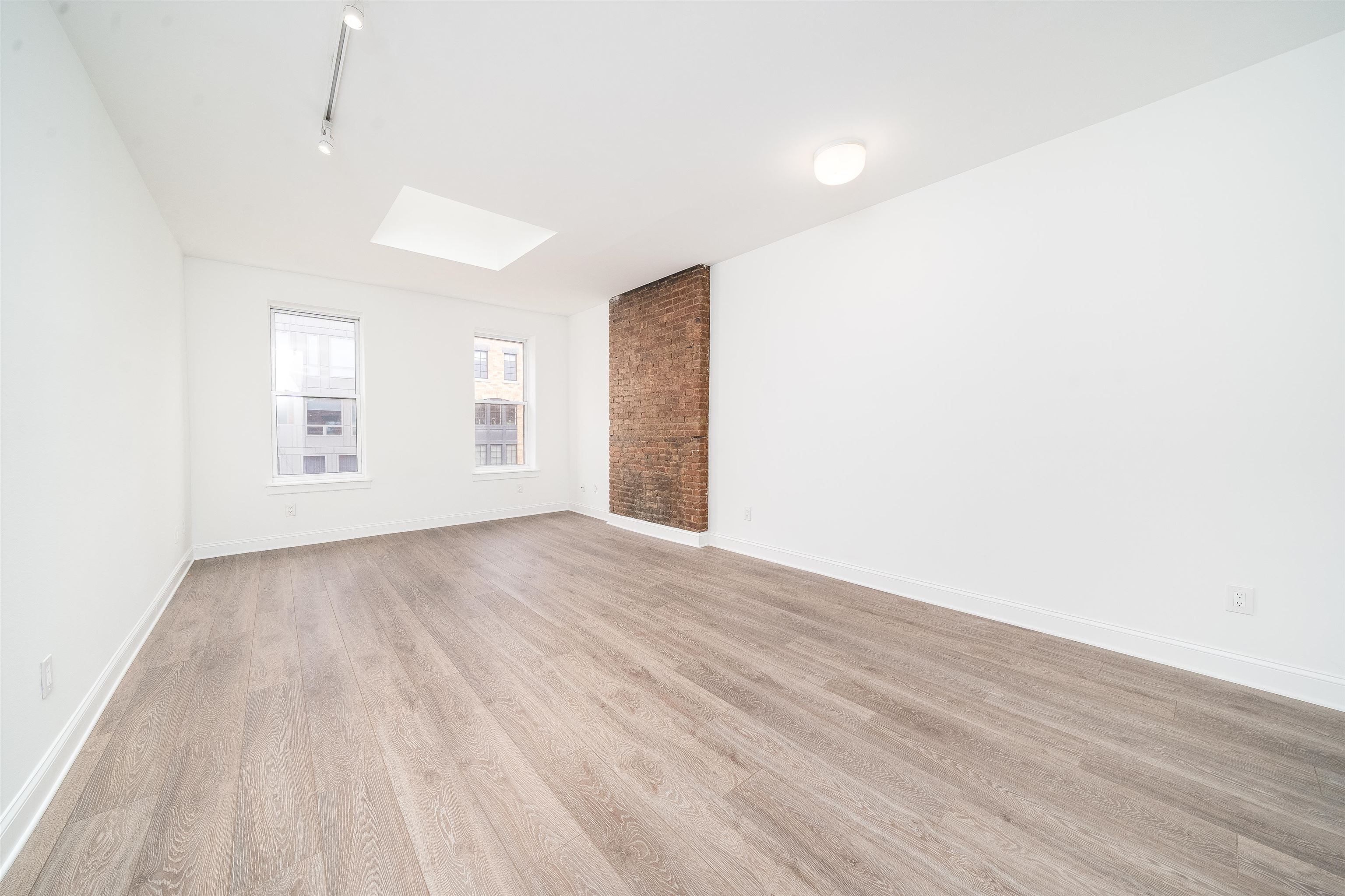 157 14th Street, Unit 5L Hoboken, NJ 07030 - Photo 1 of 11 a view of an empty room with wooden floor and a window