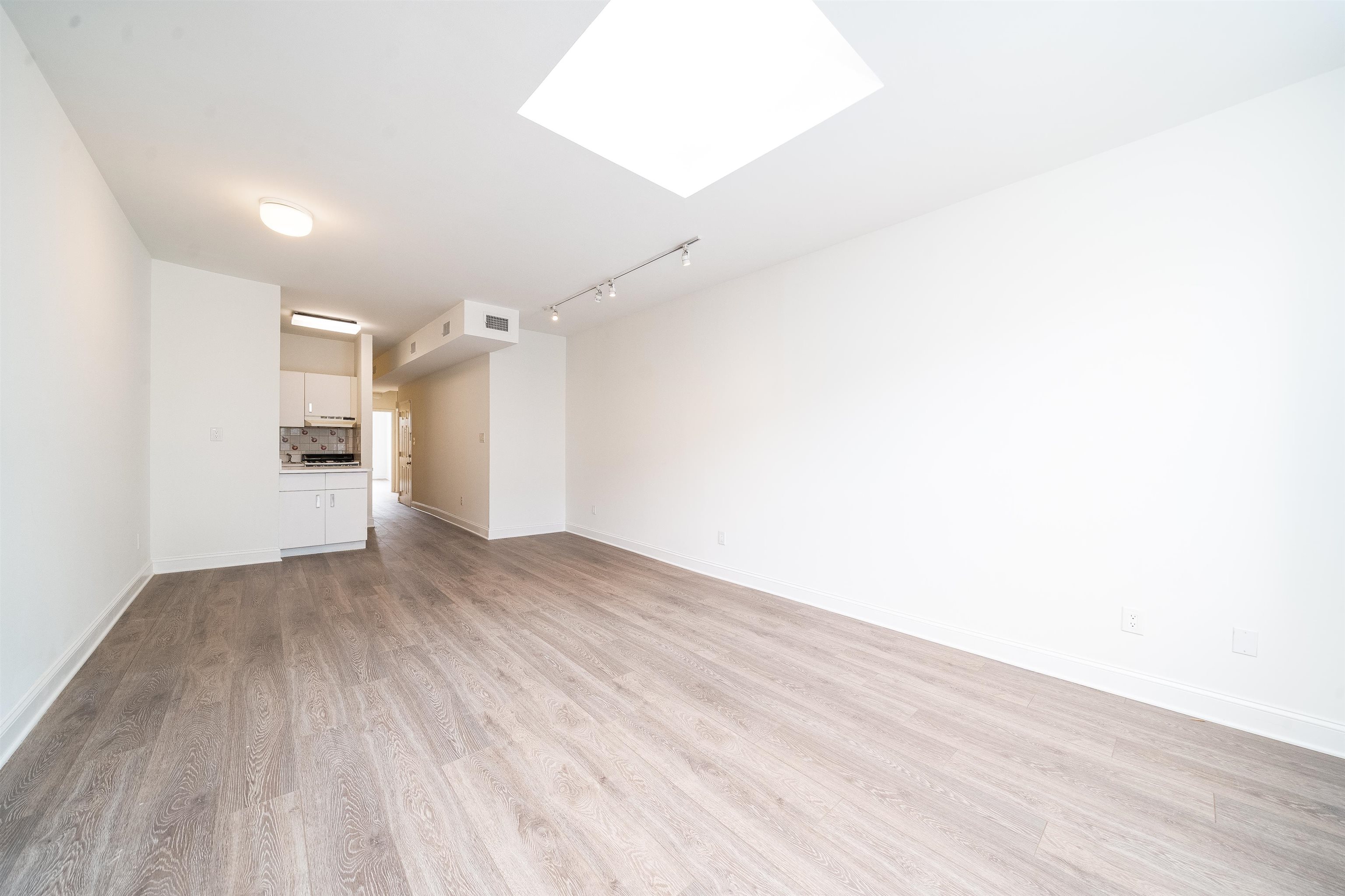 157 14th Street, Unit 5L Hoboken, NJ 07030 - Photo 2 of 11 a view of a big room with wooden floor and a ceiling fan