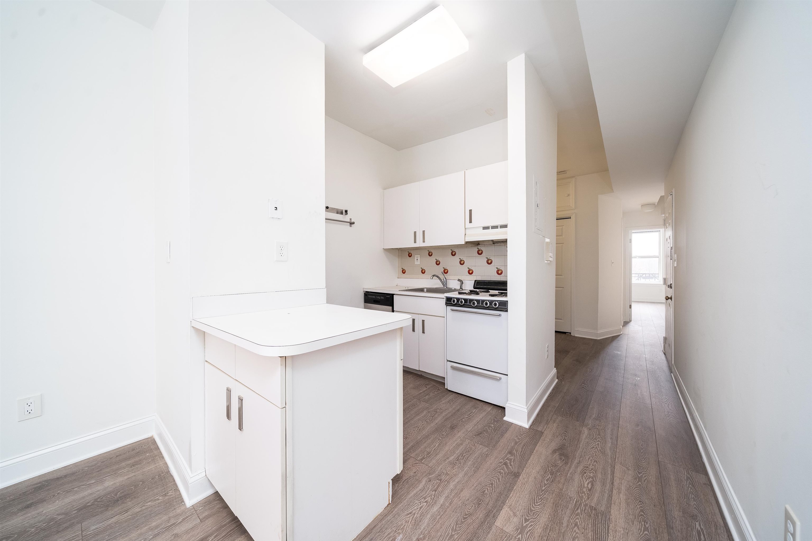 157 14th Street, Unit 5L Hoboken, NJ 07030 - Photo 4 of 11 a kitchen with white cabinets and white appliances