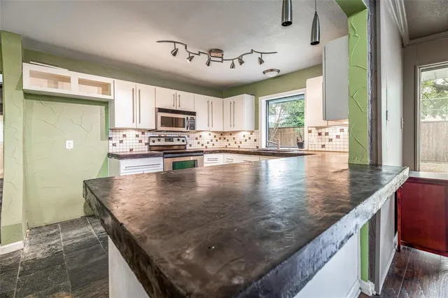 a kitchen with kitchen island a sink window and cabinets